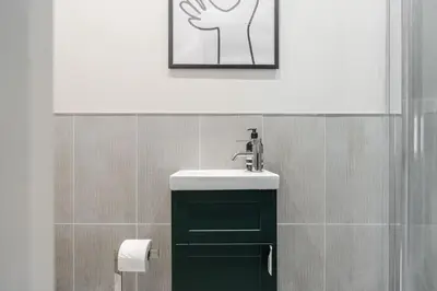 a bathroom with a sink and a picture on the wall at Charlottes Place in Liverpool