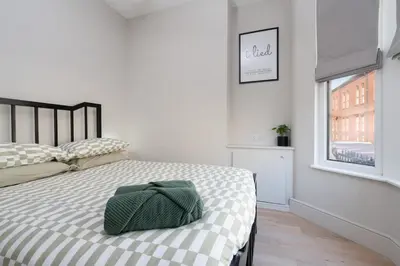 a bedroom with a bed with a green bag on it at Charlottes Place in Liverpool