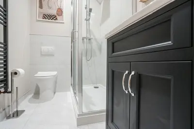 a bathroom with a shower and a black cabinet at Charlottes Place in Liverpool