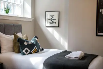 a bedroom with a bed with black and white pillows at Picasso's Place Liverpool Apt Sleeps 9 in Liverpool