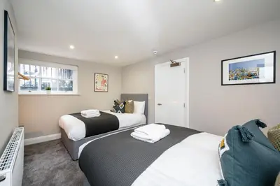 a bedroom with two beds and a tv in it at Picasso's Place Liverpool Apt Sleeps 9 in Liverpool