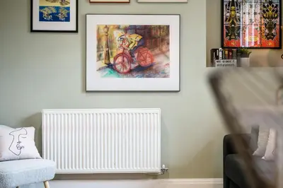 a living room with a radiator and a painting on the wall at Lennon's Place Central Apartment Sleeps 5! in Liverpool