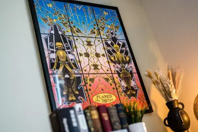 a painting on a wall with books on a shelf at Lennon's Place Central Apartment Sleeps 5! in Liverpool