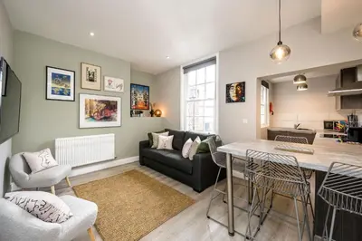 a living room with a couch and a table at Lennon's Place Central Apartment Sleeps 5! in Liverpool