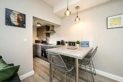 a kitchen with a table and chairs in a room at Lennon's Place Central Apartment Sleeps 5! in Liverpool