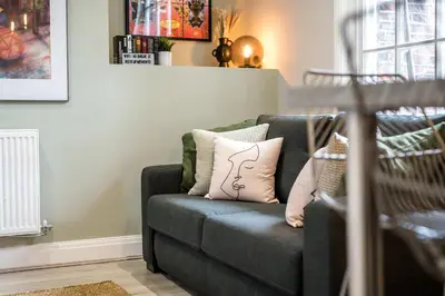 a couch with pillows on it in a living room at Lennon's Place Central Apartment Sleeps 5! in Liverpool