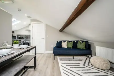 a living room with a blue couch and a table at Attico, 2BR City Centre Apartment, Sleeps 6! in Liverpool