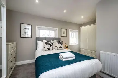 a bedroom with a large bed with a blue blanket at Attico, 2BR City Centre Apartment, Sleeps 6! in Liverpool