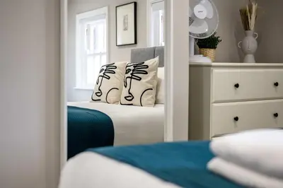 a bedroom with a mirror and a bed with pillows at Attico, 2BR City Centre Apartment, Sleeps 6! in Liverpool