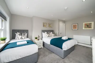 two beds in a bedroom with white and blue at Attico, 2BR City Centre Apartment, Sleeps 6! in Liverpool
