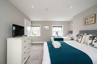 a bedroom with two beds and a flat screen tv at Attico, 2BR City Centre Apartment, Sleeps 6! in Liverpool