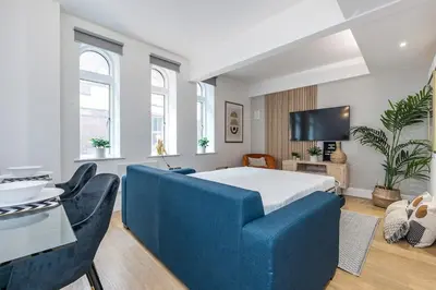 a bedroom with a blue bed and two chairs at Liverpool City Centre Apartment in Liverpool