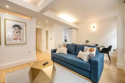 a living room with a blue couch and a table at Liverpool City Centre Apartment in Liverpool