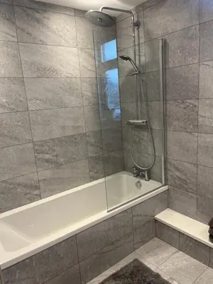 a bathroom with a shower with a white tub at Chestnut House in Southport