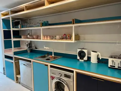 a kitchen with a blue counter top with a washing machine at Chestnut House in Southport
