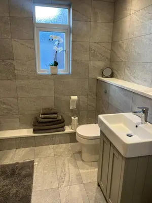 a bathroom with a toilet and a sink and a window at Chestnut House in Southport