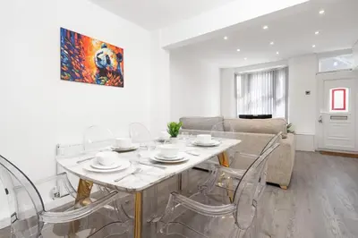 a white living room with a table and chairs at Beautiful House - Free Parking - 5 mins to centre in Liverpool