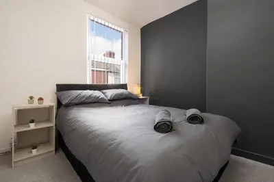 a bedroom with a large bed and a window at Beautiful House - Free Parking - 5 mins to centre in Liverpool