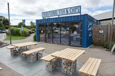 a group of picnic tables in front of a store at Miarlo Lodge Derwent Haven Lakeland in Grange Over Sands