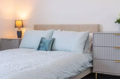 a bedroom with a white bed with blue pillows at Brand-New 3-Bed Home - Liverpool in Liverpool