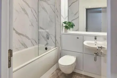 a white bathroom with a toilet and a sink at Ropewalks Retreat III - Sleeping 8 Guests with Parking in Liverpool