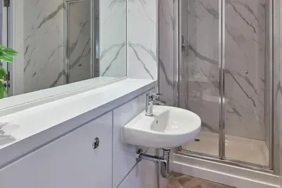 a white bathroom with a sink and a shower at Ropewalks Retreat III - Sleeping 8 Guests with Parking in Liverpool