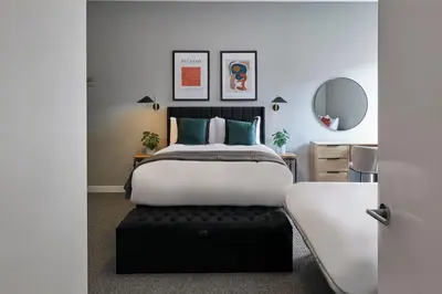 a bedroom with a large bed with a black ottoman at Ropewalks Retreat III - Sleeping 8 Guests with Parking in Liverpool