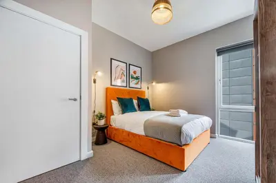 a bedroom with a large bed with blue pillows at Ropewalks Retreat IV Sleeping 6 Guests with Parking and Balcony in Liverpool