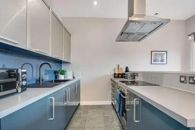 a large kitchen with blue and white walls and counters at Ropewalks Retreat IV Sleeping 6 Guests with Parking and Balcony in Liverpool
