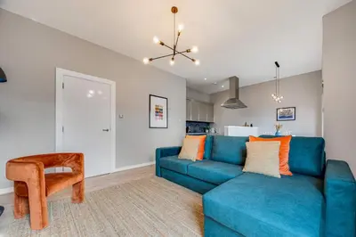 a living room with a blue couch and a table at Ropewalks Retreat IV Sleeping 6 Guests with Parking and Balcony in Liverpool