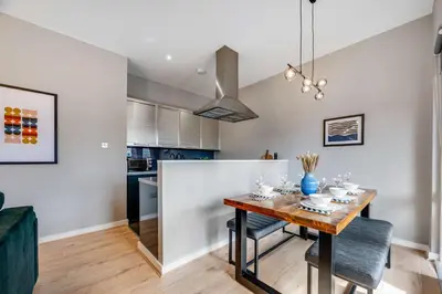 a kitchen and dining room with a table and chairs at Ropewalks Retreat IV Sleeping 6 Guests with Parking and Balcony in Liverpool