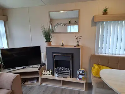 a living room with a tv and a fireplace at 11 Borwick Lakes in Carnforth