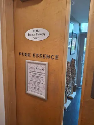 a wooden door with a sign that reads to the beauty therapyulse pure essence at 11 Borwick Lakes in Carnforth