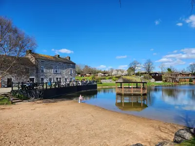 a small child standing on the shore of a river at 11 Borwick Lakes in Carnforth