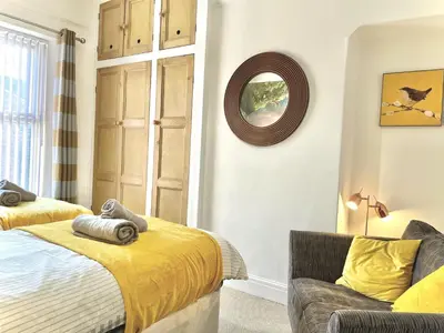 a bedroom with a bed and a chair and a mirror at Modern 4-bed stay-away-home sleeps 8 in Preston in Preston