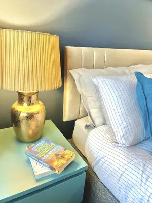 a lamp on a night stand next to a bed at Modern 4-bed stay-away-home sleeps 8 in Preston in Preston