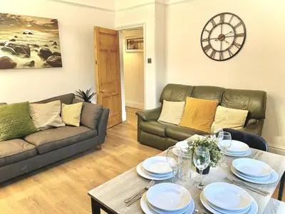 a living room with two couches and a table at Modern 4-bed stay-away-home sleeps 8 in Preston in Preston