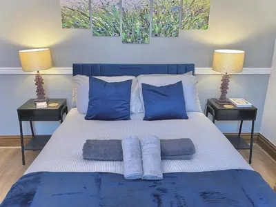 a bedroom with a bed with blue pillows and two lamps at Modern 4-bed stay-away-home sleeps 8 in Preston in Preston