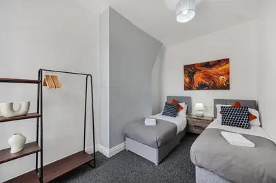 a room with two beds and a chair at Cameron House - Air Host & Stay - Contractor Friendly in Liverpool