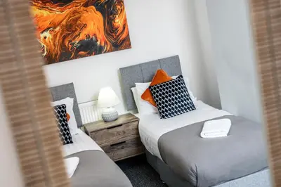 a bedroom with two beds and a painting on the wall at Cameron House - Air Host & Stay - Contractor Friendly in Liverpool