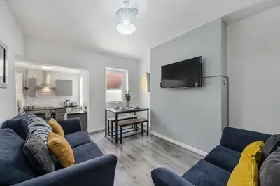 a living room with a blue couch and a kitchen at Cameron House - Air Host & Stay - Contractor Friendly in Liverpool