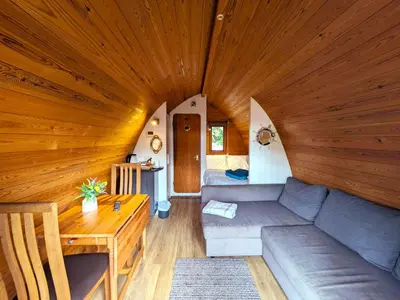 a living room with a couch and a wooden ceiling at The Golden Ball Hotel Pods in Torrisholme