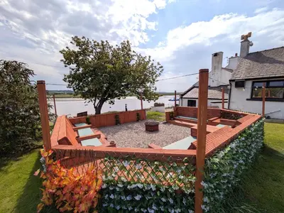 a backyard with a wooden fence and a bench at The Golden Ball Hotel Pods in Torrisholme