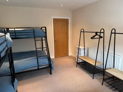 two bunk beds in a room with a door at Modern, sleeps 5, parking, semi rural, Upholland in Upholland