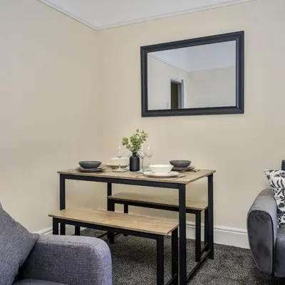 a living room with a table and a mirror at Liverpool 3 Bedroom Contractor Stay Cherry House in Liverpool