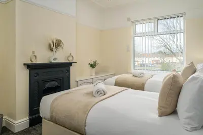 two beds in a bedroom with a fireplace at Liverpool 3 Bedroom Contractor Stay Cherry House in Liverpool