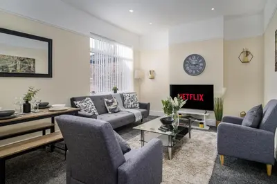 a living room with couches and a table and a fireplace at Liverpool 3 Bedroom Contractor Stay Cherry House in Liverpool