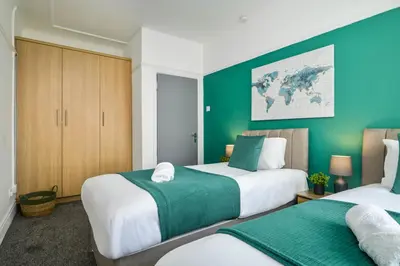 two beds in a room with green walls at Liverpool 3 Bedroom Contractor Stay Cherry House in Liverpool