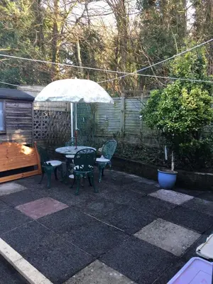 a patio with a table and chairs and an umbrella at Book 3 or more nights get one night free !!! in Bare