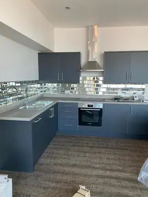 a large kitchen with blue cabinets and a sink at Clock Tower Apartments No3 in Morecambe